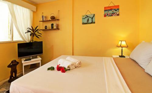 曼巴豪库尔马生态海滩度假村的卧室配有带鲜花的白色床
