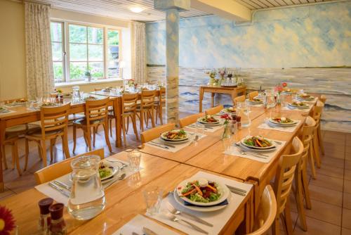 霍恩森林小屋酒店的用餐室配有桌椅和食物