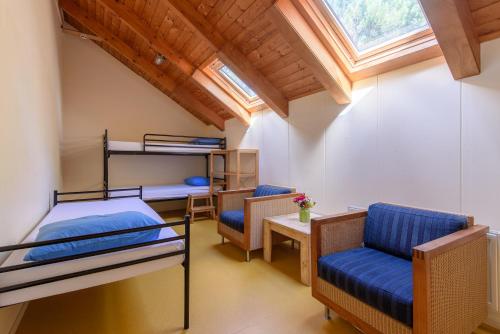 霍恩森林小屋酒店的客房设有两张双层床和一张桌子及椅子。