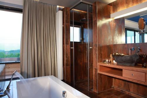 阿尔泽特河畔埃施七号酒店的设有带浴缸和淋浴的浴室。
