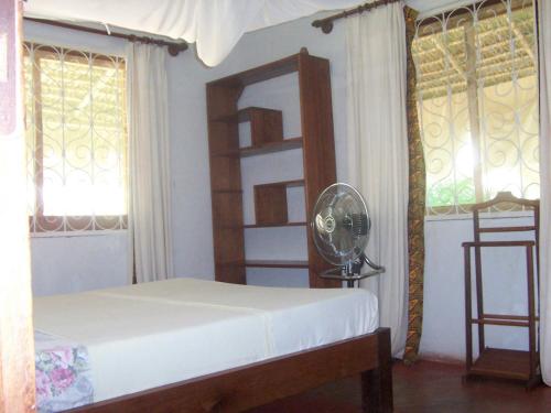 马哈赞加Villa Miadana的卧室配有床、镜子和窗户。