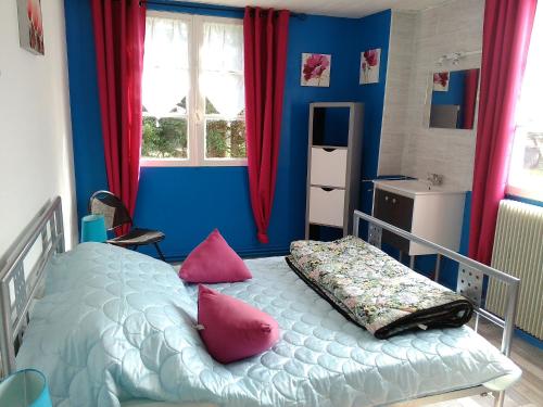 阿杜尔河畔艾尔卡斯特拉度假屋的蓝色卧室,配有带粉红色枕头的床