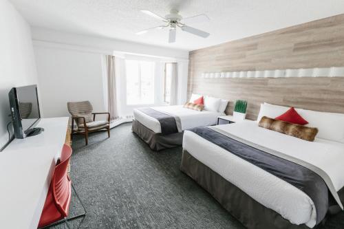班夫麋鹿+大道酒店的酒店客房设有两张床和一台平面电视。