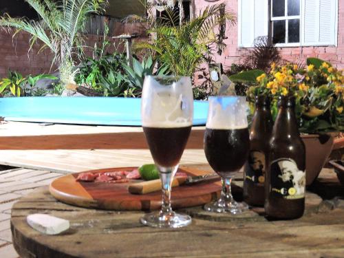 弗洛里亚诺波利斯Pousada Villa da Nascente的桌子上放两杯啤酒和瓶子