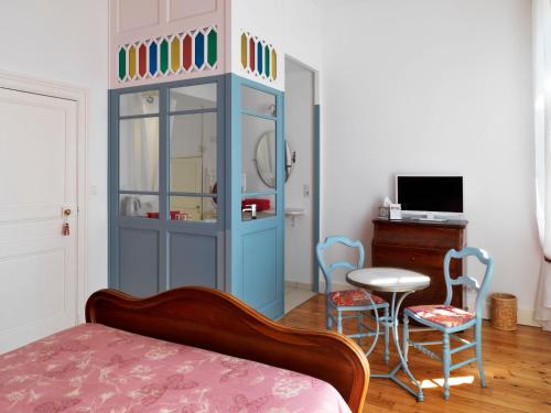 图卢兹里亚别墅住宿加早餐旅馆的一间卧室配有带椅子和桌子的蓝色橱柜