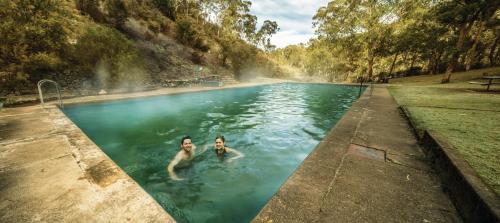 Yarrangobilly亚仁勾比利岩洞之家度假村的两人在游泳池游泳