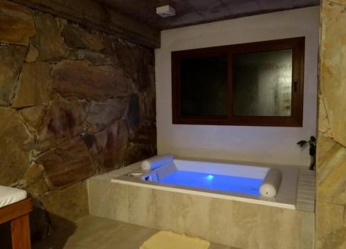 卡里罗Punta Cerezo的浴室设有蓝色的石墙浴缸