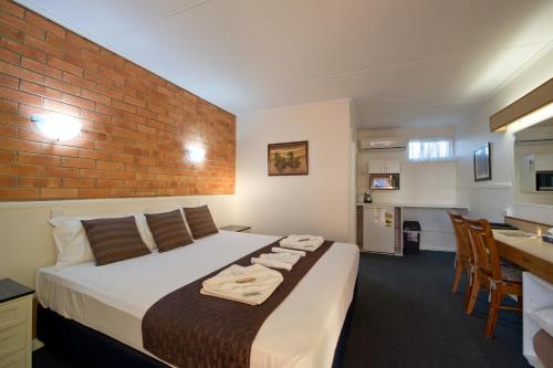 玛丽伯勒矿物金沙汽车旅馆 的一间卧室设有一张床和砖墙
