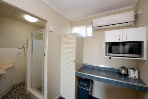 玛丽伯勒矿物金沙汽车旅馆 的小厨房配有白色橱柜和微波炉