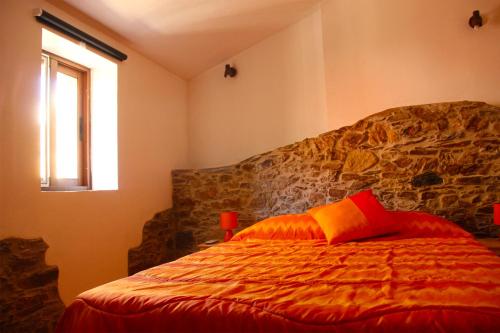 CarregaisCasas dos Carregais的一间卧室配有一张红色枕头的床