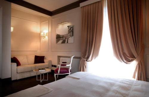 佛罗伦萨Be ONE - Ricci Collection的酒店客房,配有床和沙发