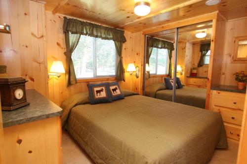 EdgertonLakeland RV Campground Loft Cabin 1的小木屋内一间卧室,配有两张床