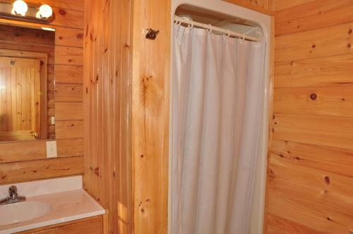 斯特金贝Tranquil Timbers Deluxe Cabin 6的浴室配有淋浴帘和盥洗盆。