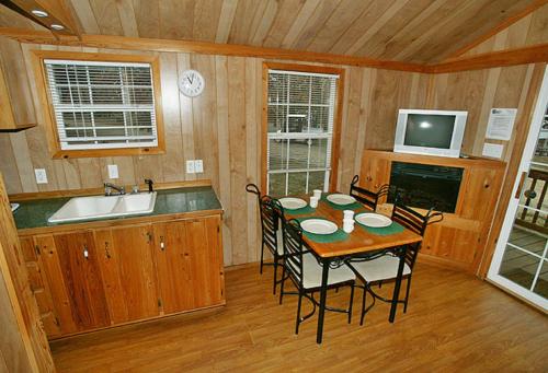 Douglas CenterArrowhead Camping Resort Deluxe Cabin 4的厨房以及带桌椅的用餐室。