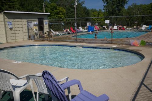 斯特金贝特朗奎尔11号假日公园的一个带两把草坪椅的游泳池和一个游泳池