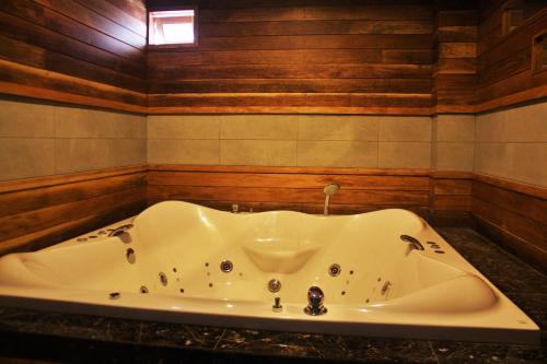 Thung Song麦特罗SPA酒店的带浴缸的浴室,设有木墙