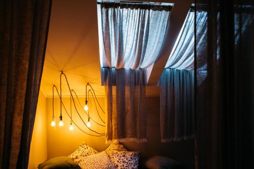 科斯特罗马Арт-отель Скворечник的一间卧室配有窗帘和一张带枕头的床。