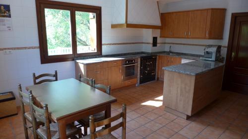 奥尼亚特Arregi2的厨房配有木制橱柜、桌子和桌椅