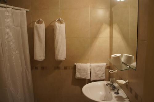 马德普拉塔Hotel Urca的浴室配有盥洗盆、淋浴和毛巾