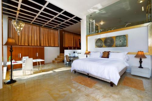 圣吉吉水果别墅酒店的卧室配有一张白色大床和一张书桌