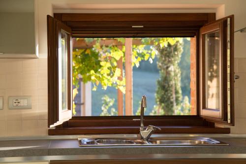 乌尔比诺Country House Ca' Brunello的厨房水槽,窗户上方是厨房柜台