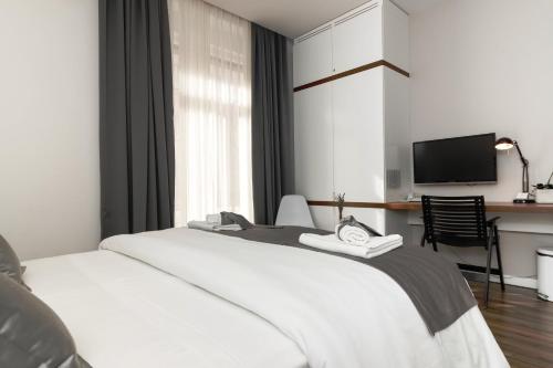斯普利特普里马豪华客房旅馆的一间酒店客房,配有一张白色的床和一张书桌