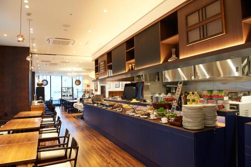 东京相铁Fresa Inn银座七丁目酒店的餐厅设有长台面,配有桌椅