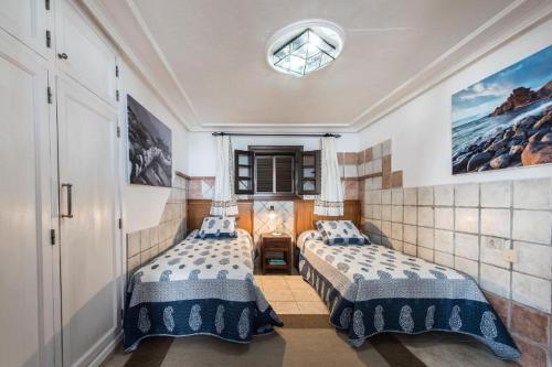 科斯塔特吉塞Villa Caracoles的一间卧室设有两张床,其中设有窗户。