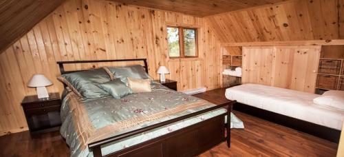 Saint Ludger de MilotLes Chalets du Lac Serein (Ludger)的小木屋内一间卧室,配有一张床