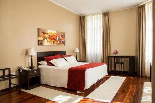 塔里哈维多利亚广场酒店的一间卧室配有一张带红色和白色枕头的大床