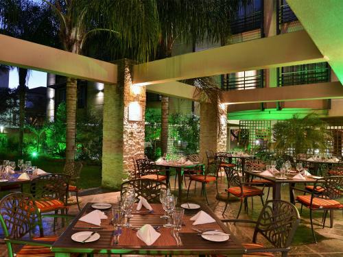 比勒陀利亚比勒陀利亚普瑞米尔酒店的庭院内带桌椅的餐厅