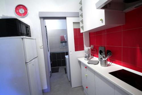 利克维Riquewihr的厨房铺有红色瓷砖,配有白色冰箱