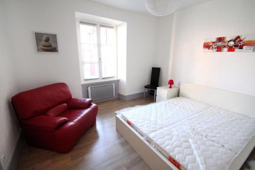 利克维Riquewihr的卧室配有白色的床和红色椅子