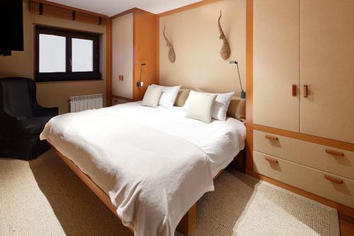 巴奎伊拉-贝莱特Pleta de Nheu 2 by FeelFree Rentals的卧室配有一张白色大床和一把椅子