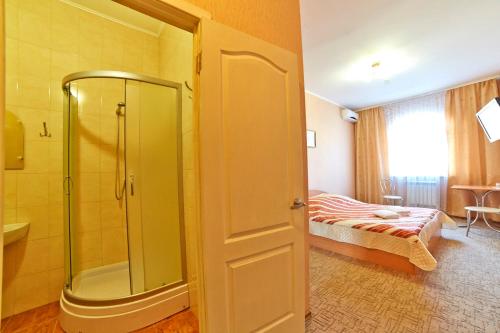 基辅三角洲酒店的带淋浴的浴室和1间带1张床的卧室