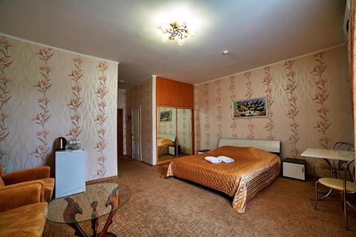 基辅三角洲酒店的一间卧室配有一张床、一张沙发和一张桌子