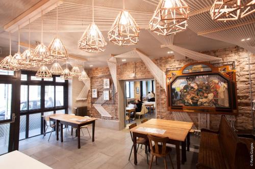 斯特拉斯堡戈拉法尔加酒店的餐厅设有桌椅和吊灯。
