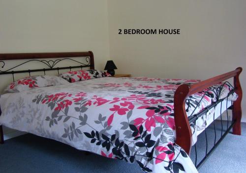 丹马克海洋海滩海德威木屋的一间卧室配有一张带花卉棉被的床