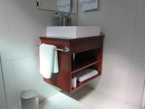 比勒陀利亚House Sandrock Muckleneuk Selfcatering apartment的浴室配有带盥洗盆和毛巾的梳妆台。