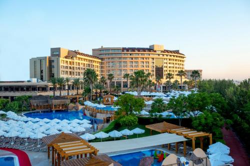 拉瑞拉拉成名公寓酒店及Spa的一座带游泳池、桌椅和建筑的度假村