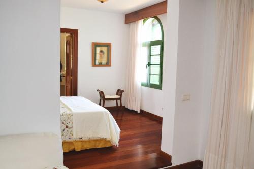 亚伊萨Vista Timanfaya的一间卧室设有一张床、一个窗口和一把椅子
