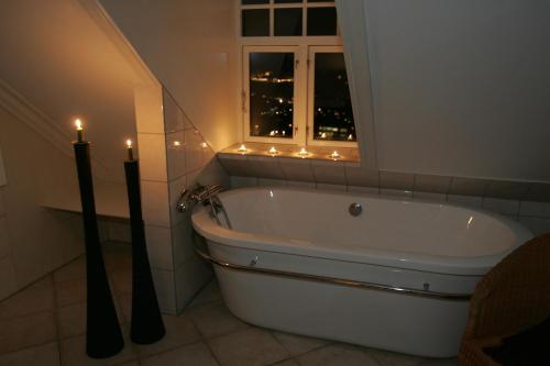 奥达Vikinghaug公寓的带浴缸的浴室,配有2把蜡烛