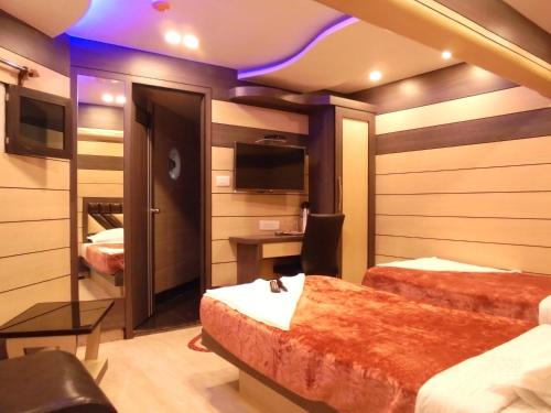 加尔各答大西部酒店的一间酒店客房,设有两张床和电视