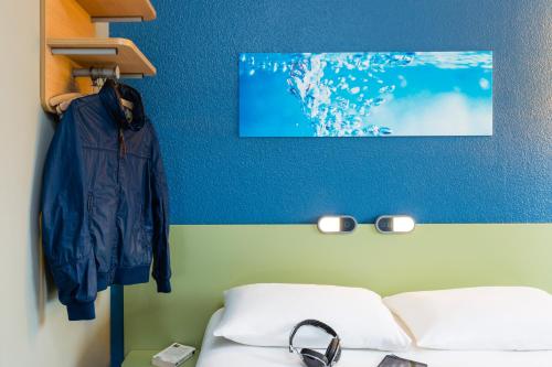 圣锡尔万当茹昂热展览公园宜必思快捷酒店的一间卧室设有两张床和蓝色的墙壁
