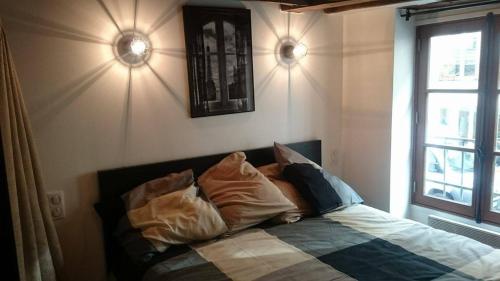 巴黎玛黑区之珠公寓的卧室配有带枕头的床铺和窗户。