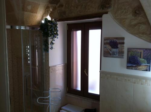 梅萨涅Porta Piccola B&B的带淋浴和卫生间的浴室以及窗户。