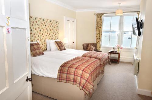 克罗默蒂The Royal Hotel Cromarty的酒店客房设有床和窗户。