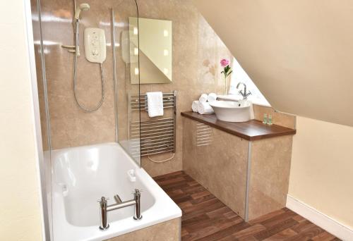 克罗默蒂The Royal Hotel Cromarty的浴室配有盥洗盆和浴缸。