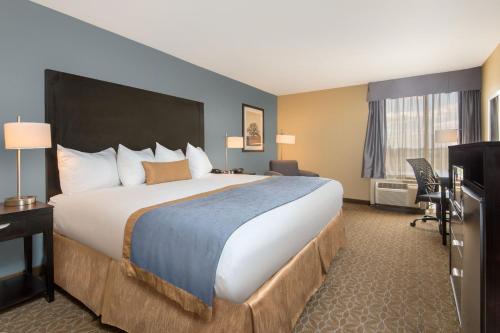 特克萨卡纳-德克萨斯Wyndham Garden Texarkana的酒店客房设有一张大床和一张书桌。