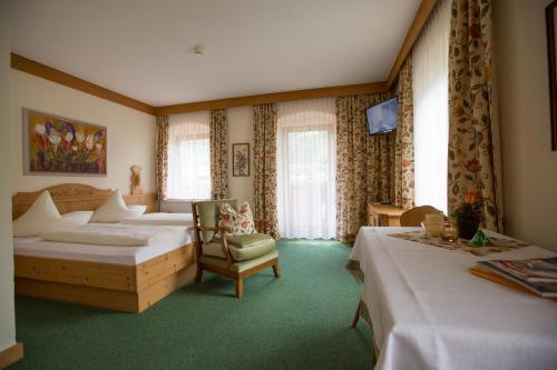 齐勒河谷采尔Hotel Garni Elisabeth的酒店客房,配有两张床和椅子